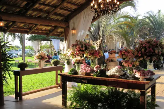 Salão coberto com mesa de apoio e arranjos de flores