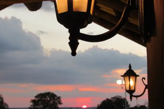 Lampião do jardim recortado contra o pôr do sol