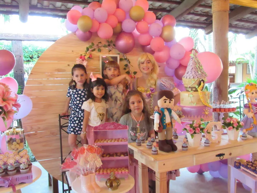 Festa infantil com balões cor-de-rosa e mesa temática