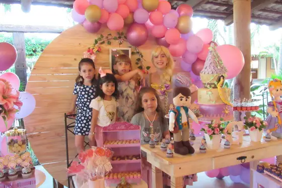 Festa infantil com balões cor-de-rosa e mesa temática