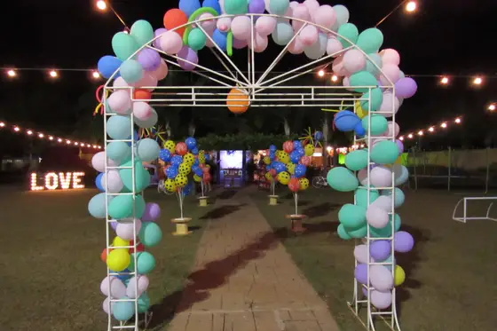Arco de balões coloridos iluminado à noite no jardim