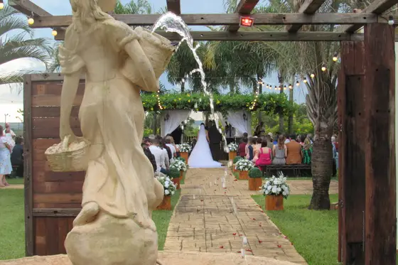 Caminho de cerimônia ladeado por vasos, com escultura de pedra