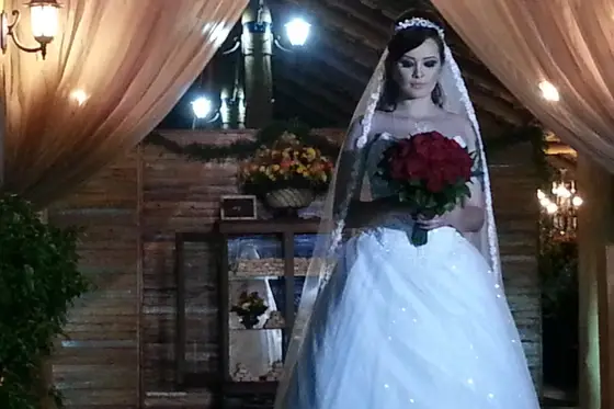 Noiva com buquê no interior do salão de madeira