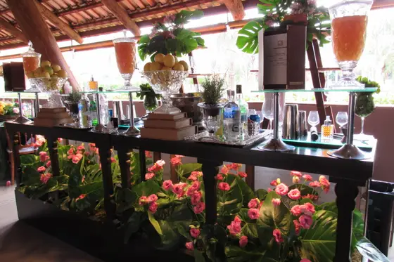 Bar montado com bebidas e arranjos de flores