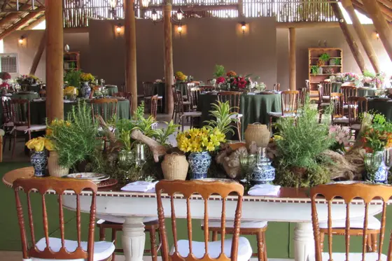 Mesa rústica posta com louça azul e arranjos de flores