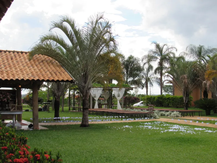 Quiosque de madeira com telhado de barro no gramado
