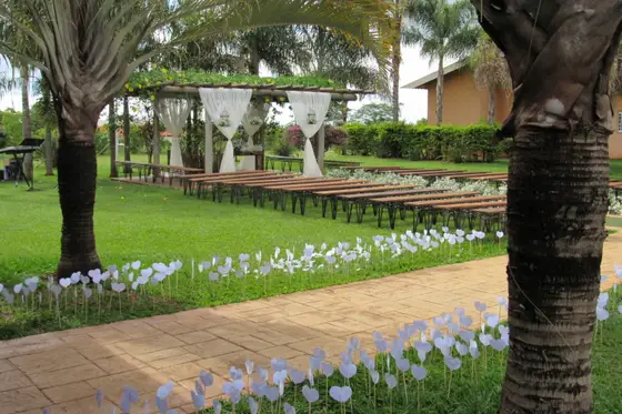 Caminho de pedra ladeado por canteiros de flores brancas