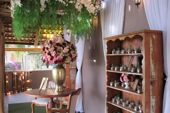 Adega decorada com flores e cortinas no interior do salão