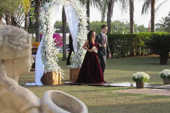 Casal de noivos no jardim junto à fonte de pedra