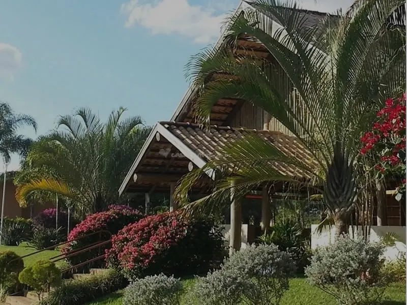 Entrada da chácara Santa Felicidade Eventos, com jardim e palmeiras